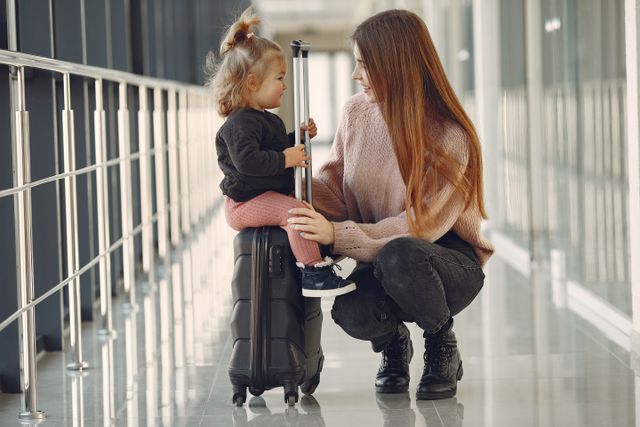A mother and daughter share a joyful moment at an airport