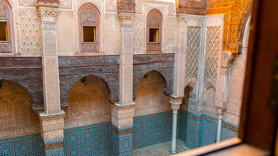 Colorful mosaic tiles, filigree plasterwork, beautiful decorations and carvings inside the madrasa.