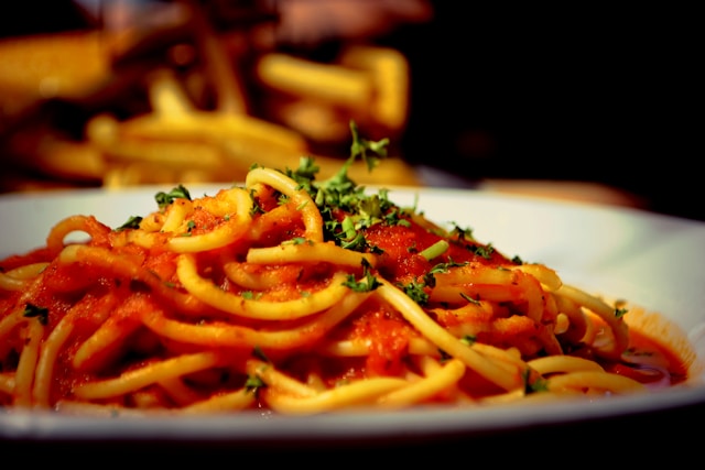 Pasta with tomato sauce shot on rustic wood table.