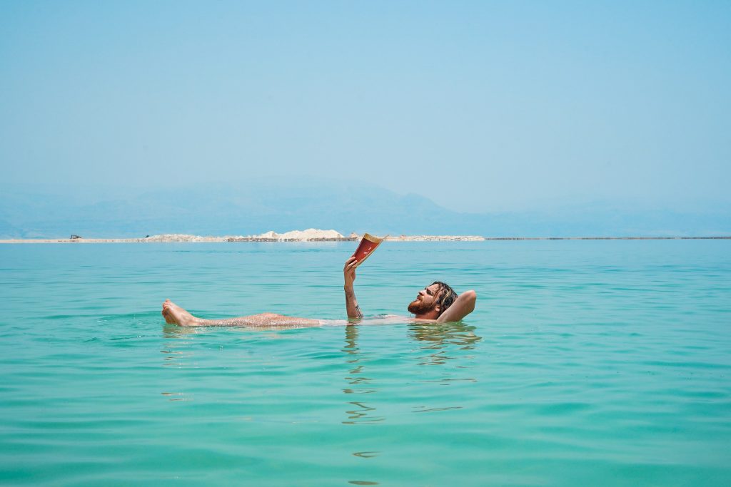 man reading while floating in the dead sea