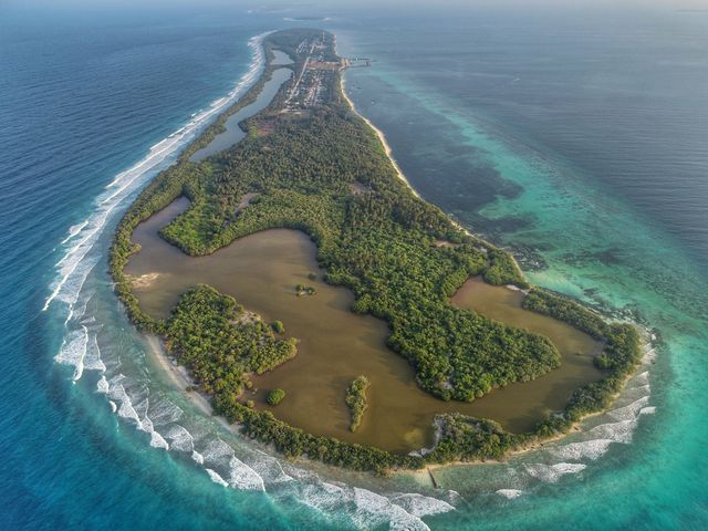 Stunning aerial view of a small Island surrounded by vibrant ocean.