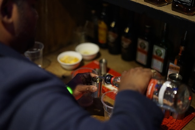Man pouring vodka into glasses in pub