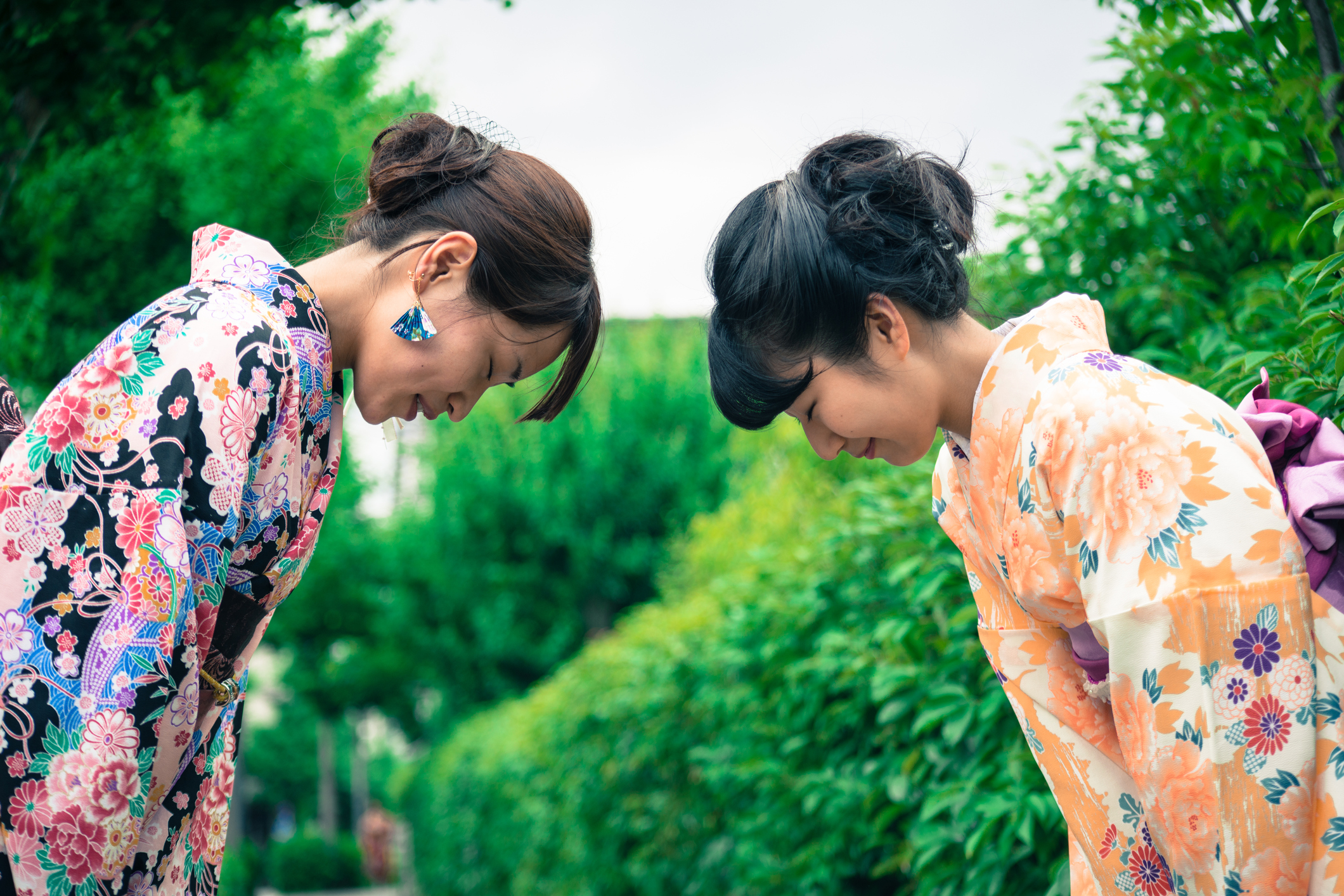 Two Japanese women in traditional kimono bowing