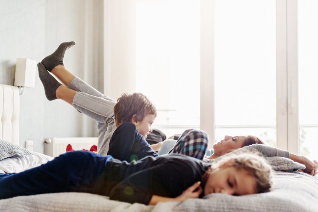 Turkish family relaxing in bed on a weekend morning