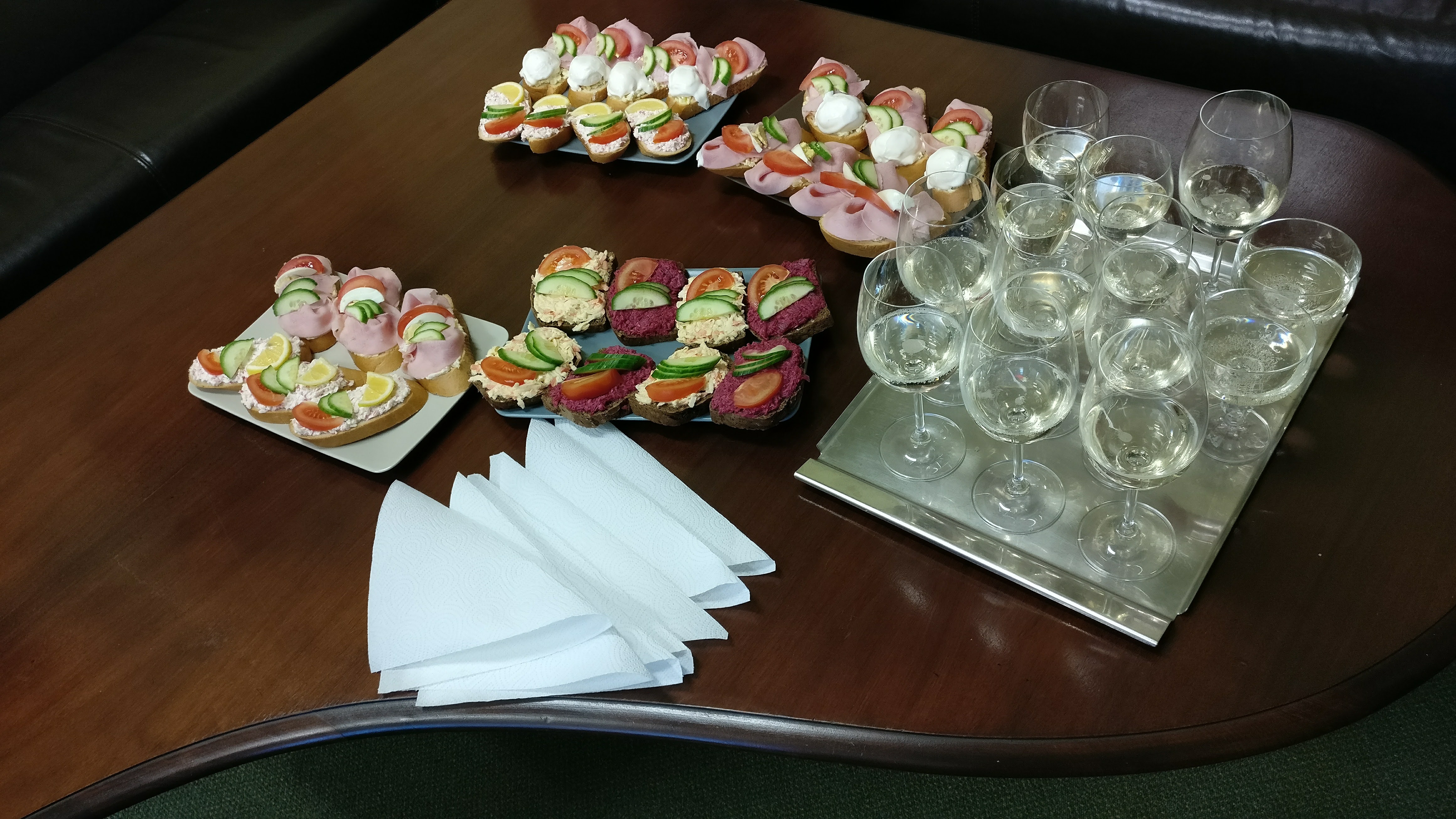 An array of Chlebíčky with different toppings on a table along with glasses of champagne -food in Prague