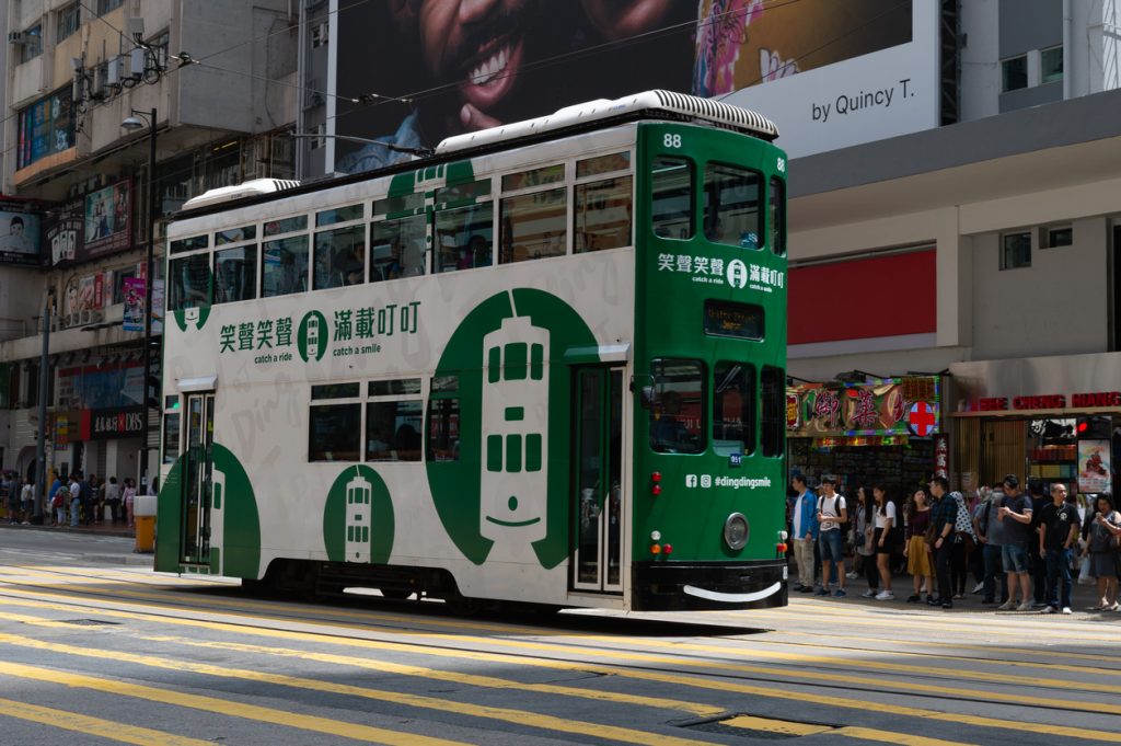  Double deck tram on busy street of Central Hong Kong. Trams is major tourist attraction and famous transportation system in HK