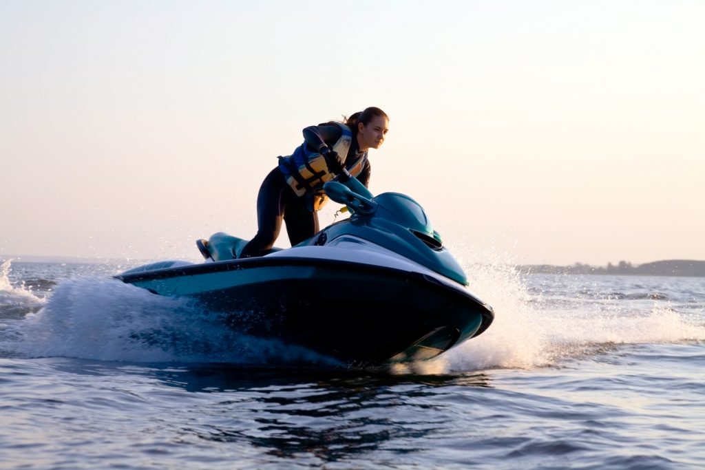 Woman on a jet ski in the ocean during the sunset