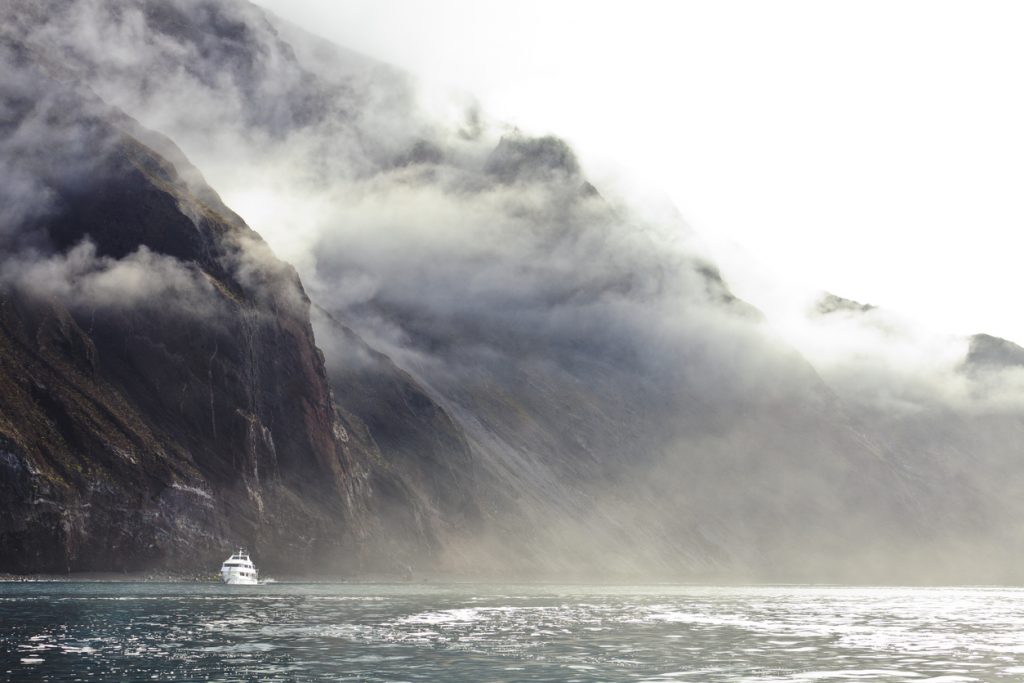 Small Cruise Ship Under Fog, Santa Cruz Island, showing the volcanic geology common to all the islands