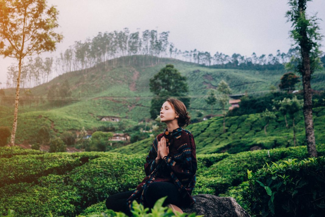 woman meditating in the tea plantations of Kerala