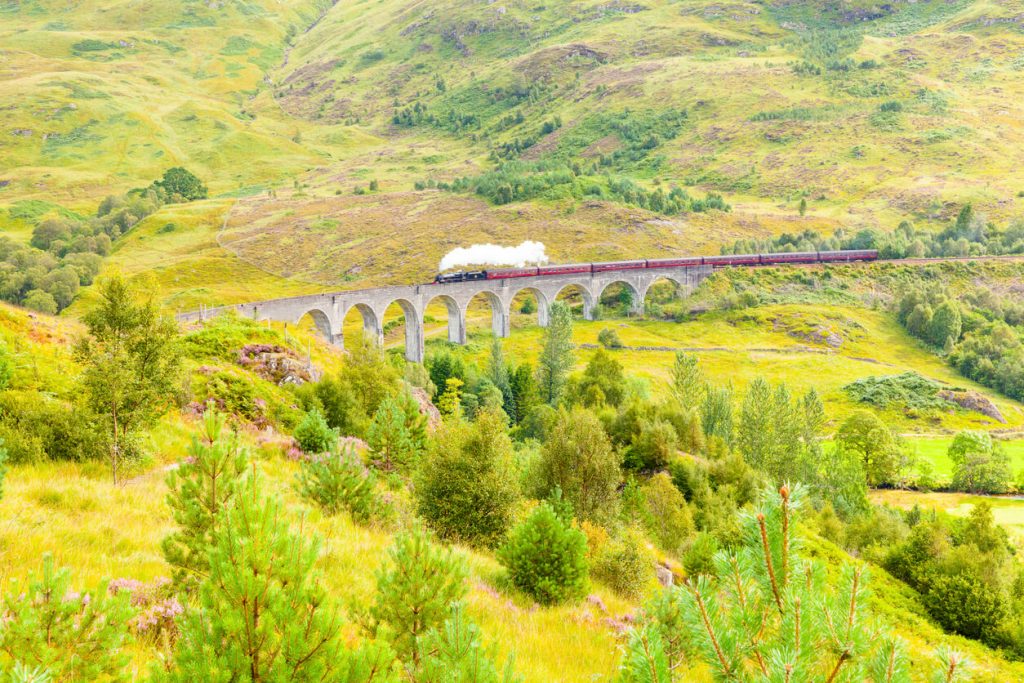 The famous Glenfinnan viaduct carries the railway to Glenfinnan Station Scotland - Scenic train routes