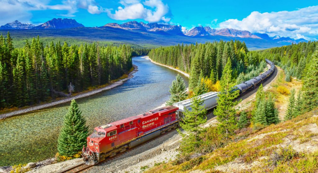 Long freight train Canadian Pacific Railway moving along Bow river in Canadian Rockies, Banff National Park, Canadian Rockies, Canada - scenic train routes