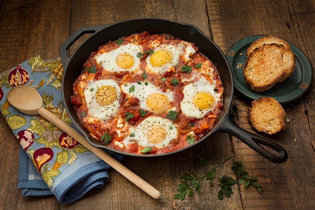 Overhead view of shakshouka on a rustic background.