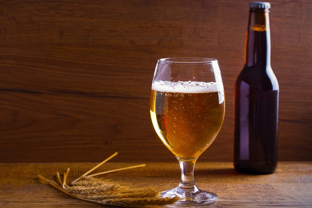 Glass and bottle of beer, ears of barley on wooden background. Ale. horizontal with copy space