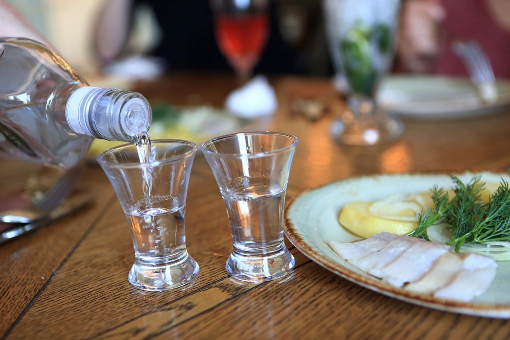 Man pouring vodka into glasses in pub