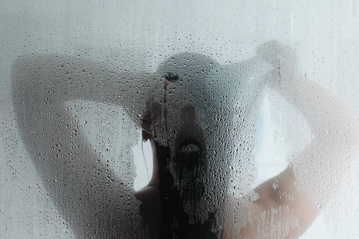 Silhouette of a woman showering with steam