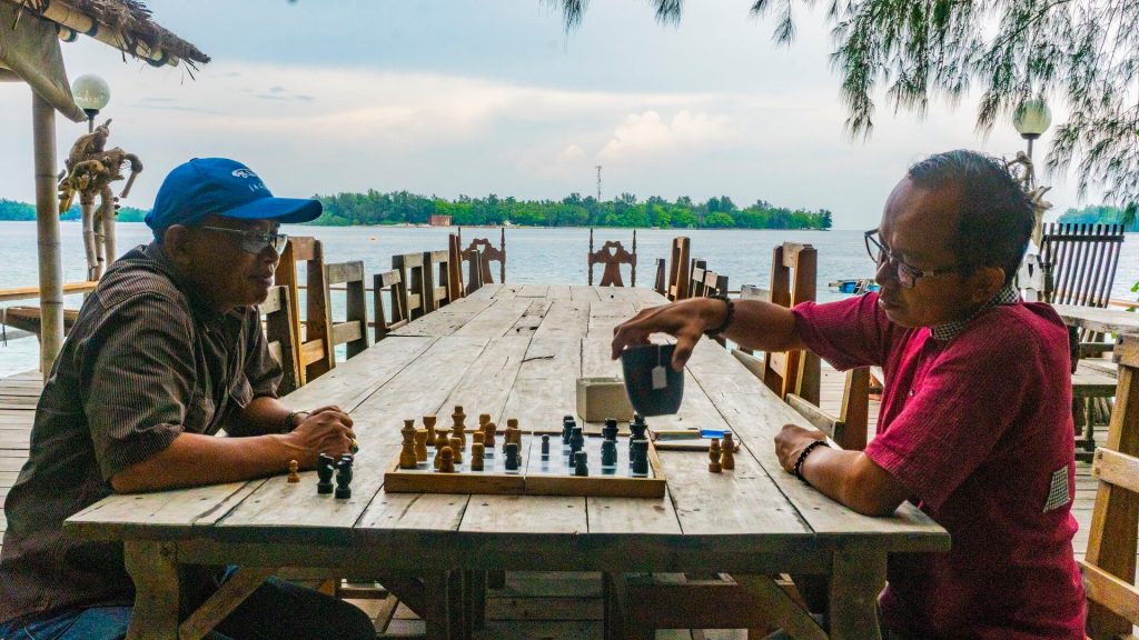 Men playing chess on Pulau Macan Island (Tiger Island)