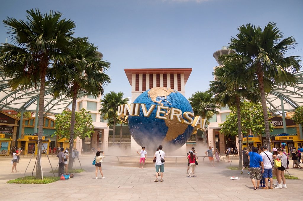 Visitors pose for photos with a revolving Universal Studios globe, outside the entrance to the Universal Studios Singapore theme park at Resorts World Sentosa. Singapore