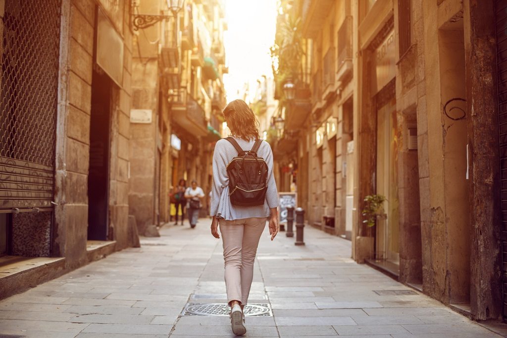 Traveling female walking on European city street, tourism in Europe, travel background