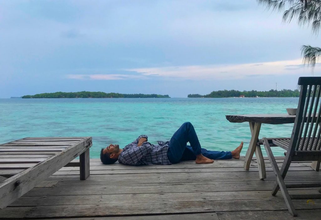 Man resting on a deck of Pulau Macan Island - Islands in Indonesia