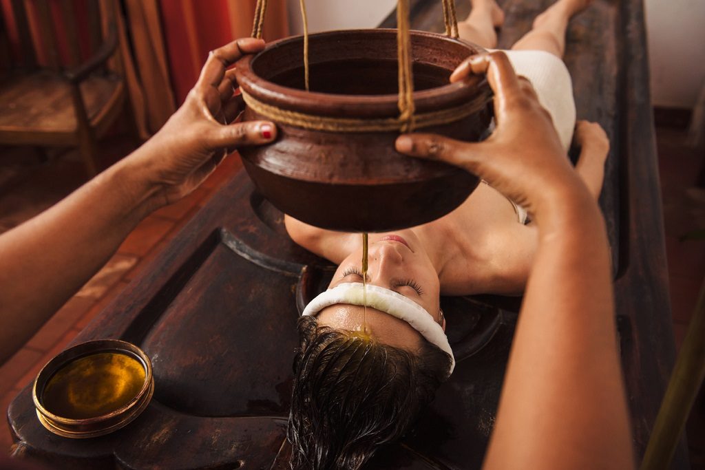 Caucasian woman having Ayurveda shirodhara treatment in India