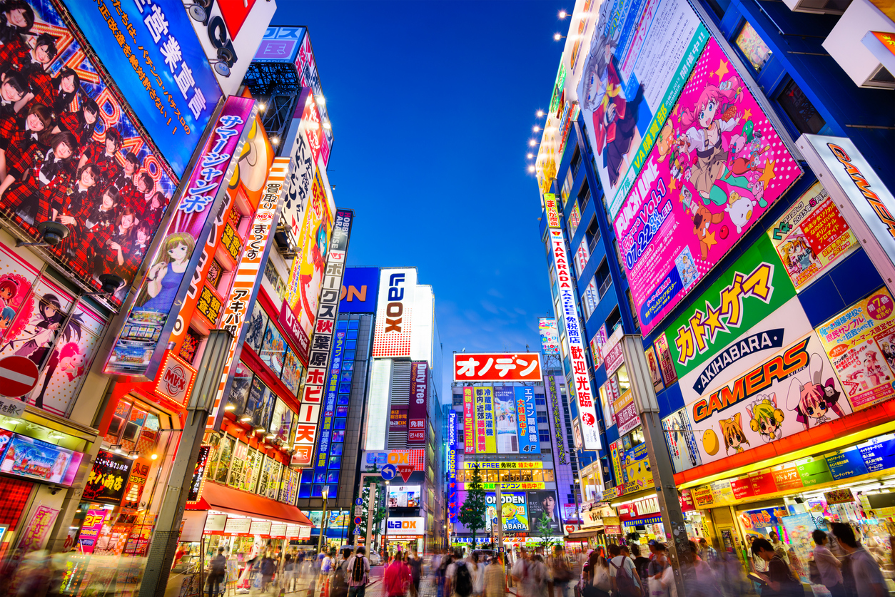 Crowds pass below colorful signs in Akihabara. The well known electronics district specializes in the sales of video games, anime, manga, and computer goods, Hogwarts