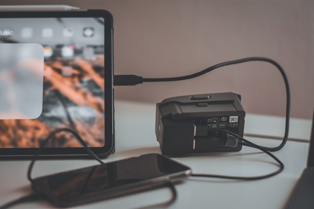 Black power bank with usb and smartphone on old vintage background.