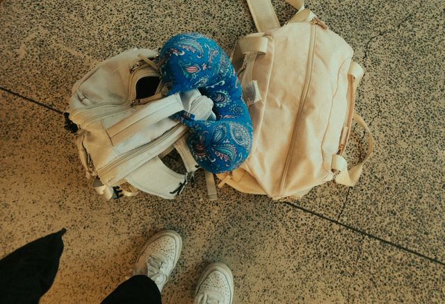 Top view of luggage, backpack, and neck pillow at airport, ready for travel