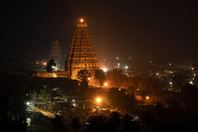 Stunning night view of the illuminated Virupaksha Temple, a UNESCO World Heritage Site in Hampi, India.