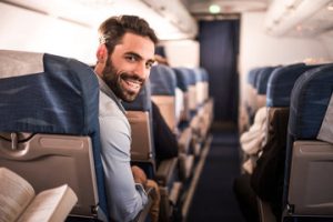 A happy business traveller sitting on a plane