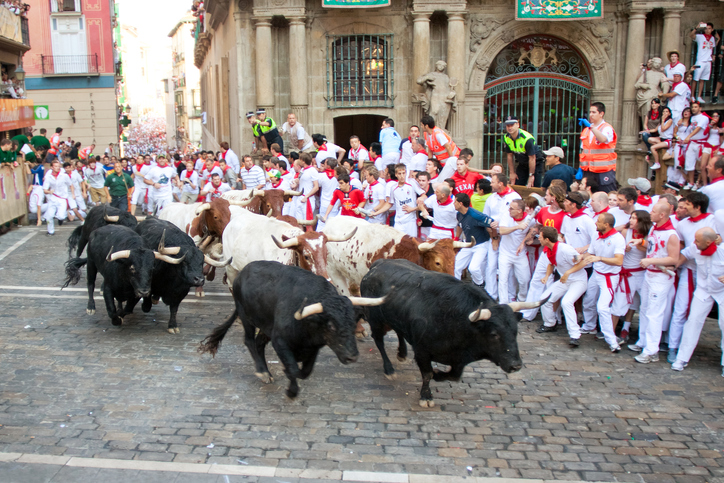 Pamplona. Spain - July 9, 2013: People run from bulls on street during San Fermin festival in Pamplona