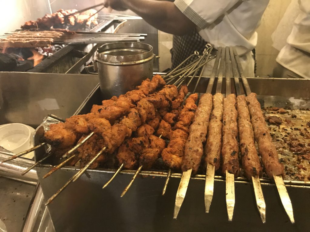 Lamb meat kebabs being grilled on skewers.