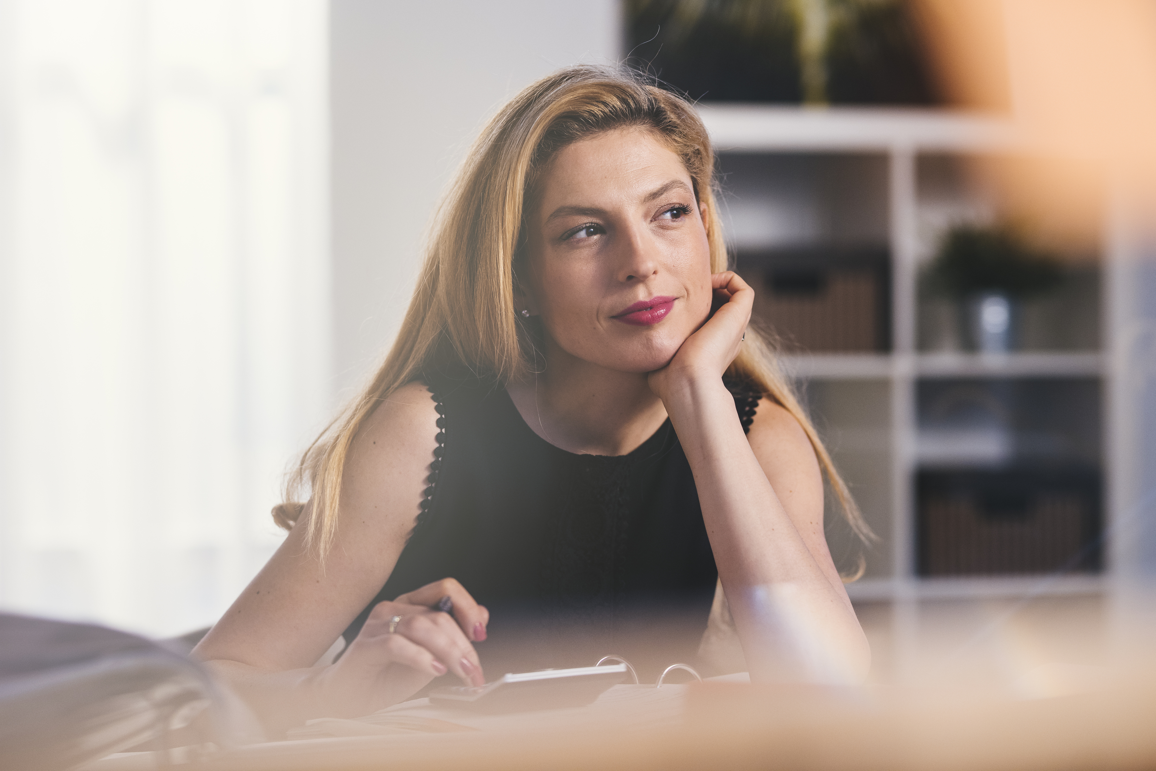 Young business woman looking away and is thoughtful about time.