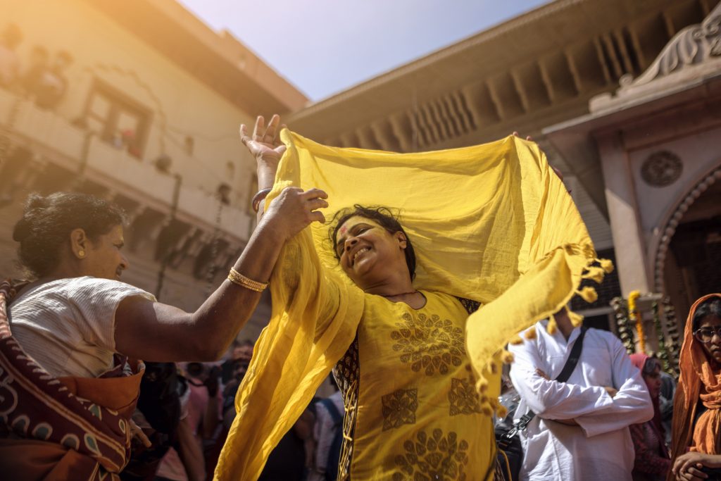 Vrindavan, Uttar Pradesh, India - Vrindavan in four-day Holi celebrations that began on February 24th.. Woman dancing on the tunes of Radhe Radhe during Holi celebrations in Vrindavan, Long Weekends