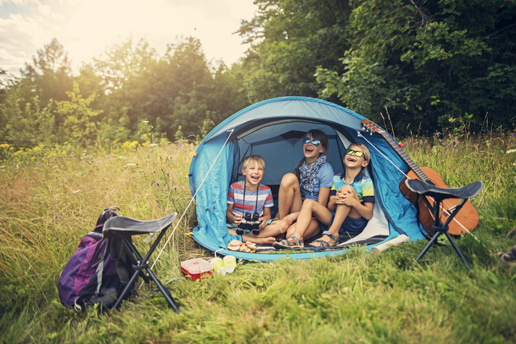 Kids having fun camping in tent on the forest meadow Adventure sports