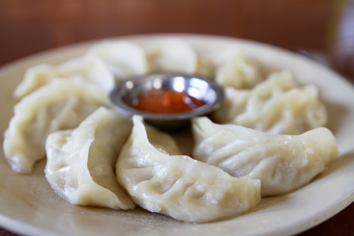 Shot of a plate of dumplings with some dipping sauce, Monsoon