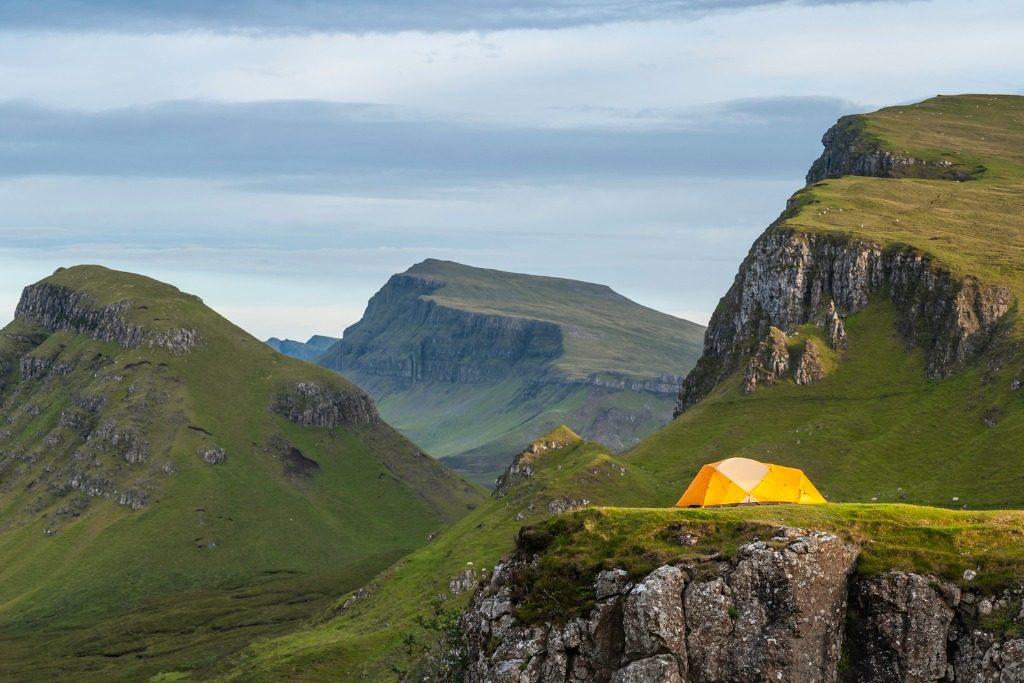 Yellow dome tent in dramatic mountain wilderness Highlands Scotland travel tips