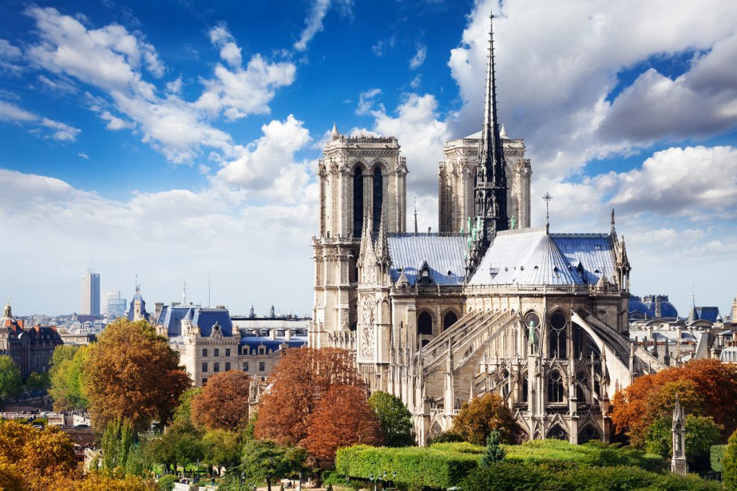 Notre Dame cathedral in Paris with panorama of Paris on background view from the roof of house on Siena