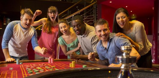 Group Of Friends Playing Roulette In Casino