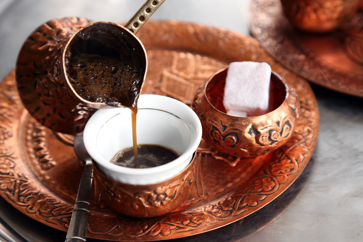 Turkish coffee being poured from the traditional cezve