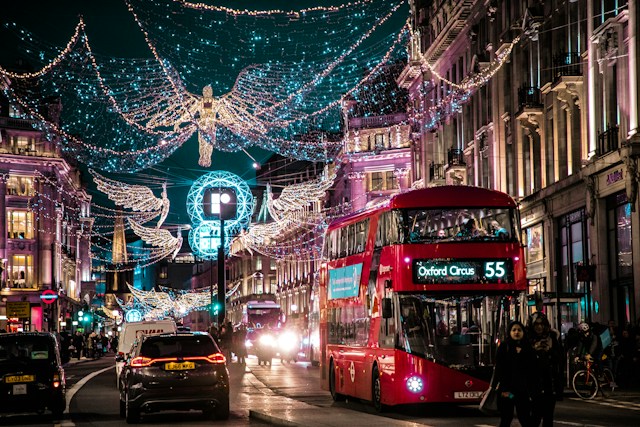Christmas shoppers amongst the lights and traffic of Oxford Street in London's main retail district