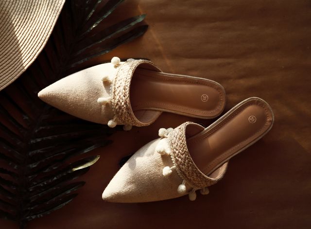 Stylish beige sandals with decorative pom-poms