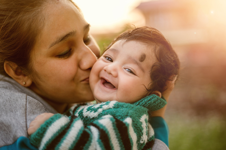 Young Indian mother kissing her beloved baby