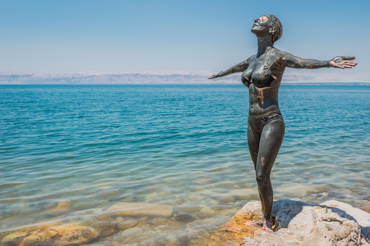 one woman applying Dead Sea mud body care treatment in Jordan