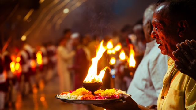 A vibrant Hindu ritual ceremony with flames and flower offerings