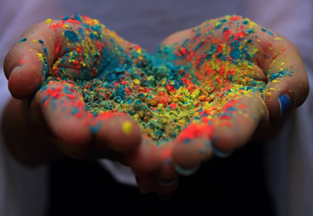 vibrant colored powders held in hands during India's Holi festival.