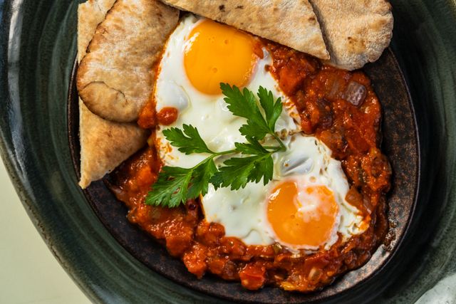 Overhead view of shakshouka on a rustic background.
